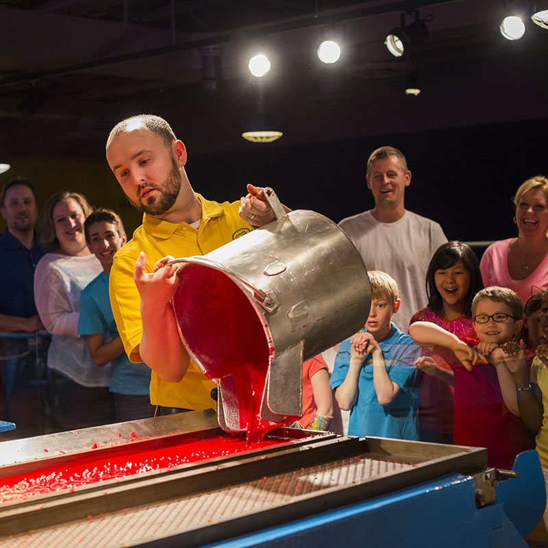 Families watching crayon wax being poured at Crayon Factory show at Crayola Experience