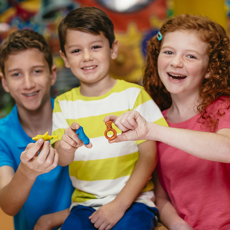 Kids holding their creations at Melt and Mold at Crayola Experience