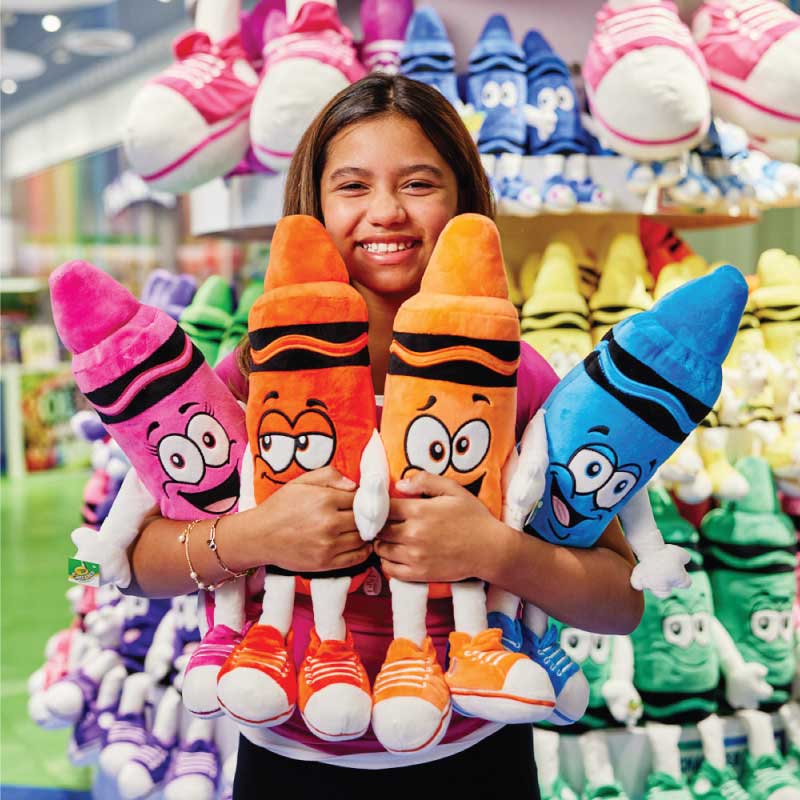 Girl holding colorful plush crayons