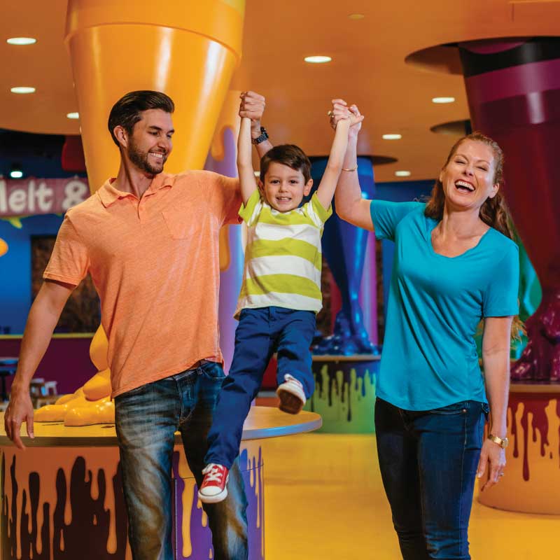 Parents lifting child at Crayola Experience