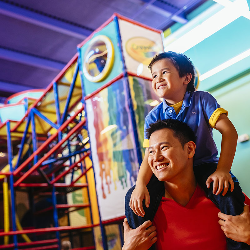 Young boy and father at the playground at Crayola Experience