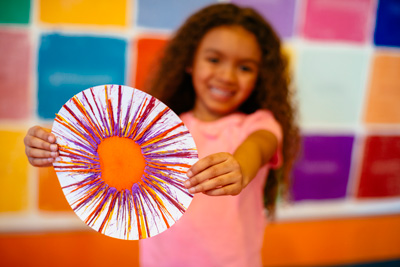 Young girl holding Spin Art at Crayola Experience
