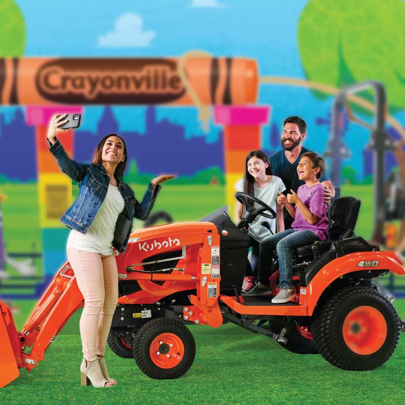 Family posing with a Kubota tractor