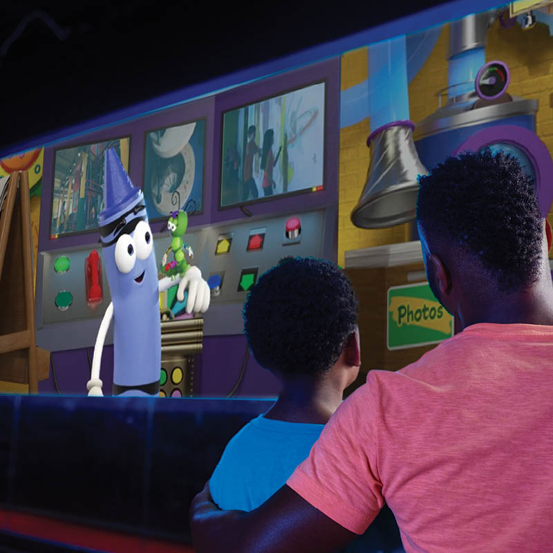 Adult and child watching show on a screen.