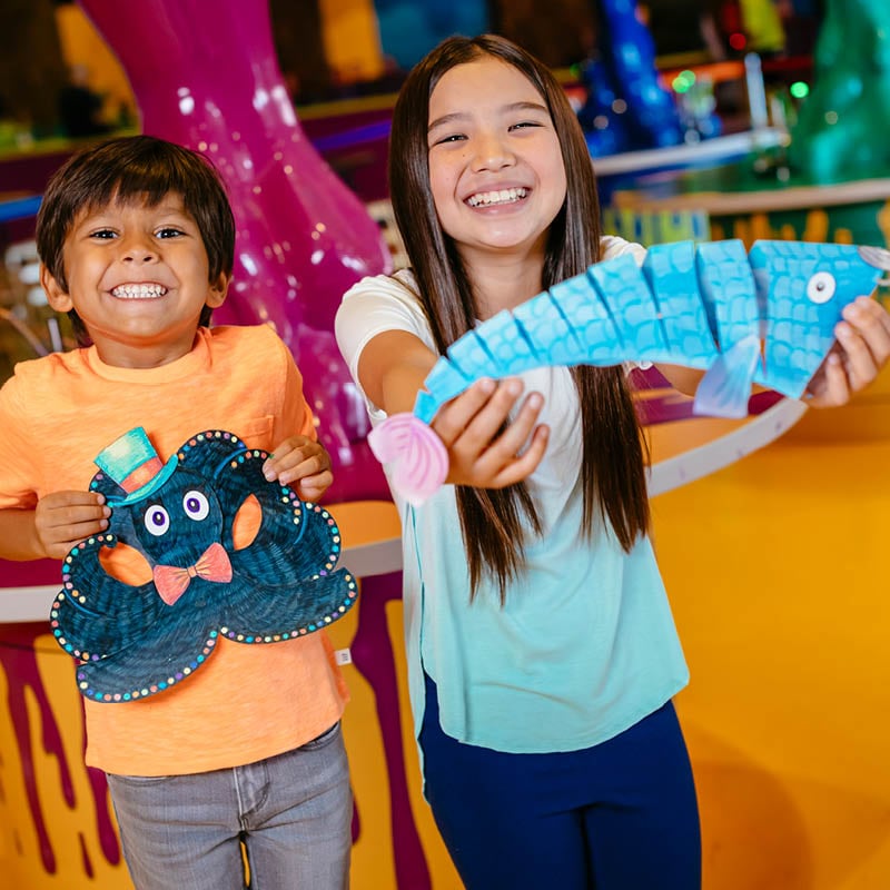 Kids holding up crafts