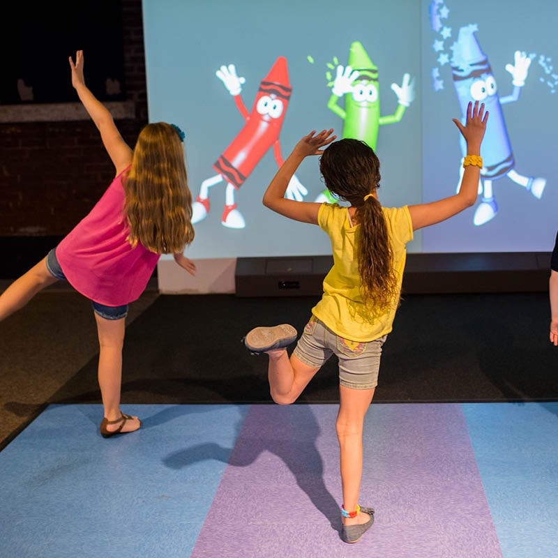 Two kids dancing with animated crayon characters