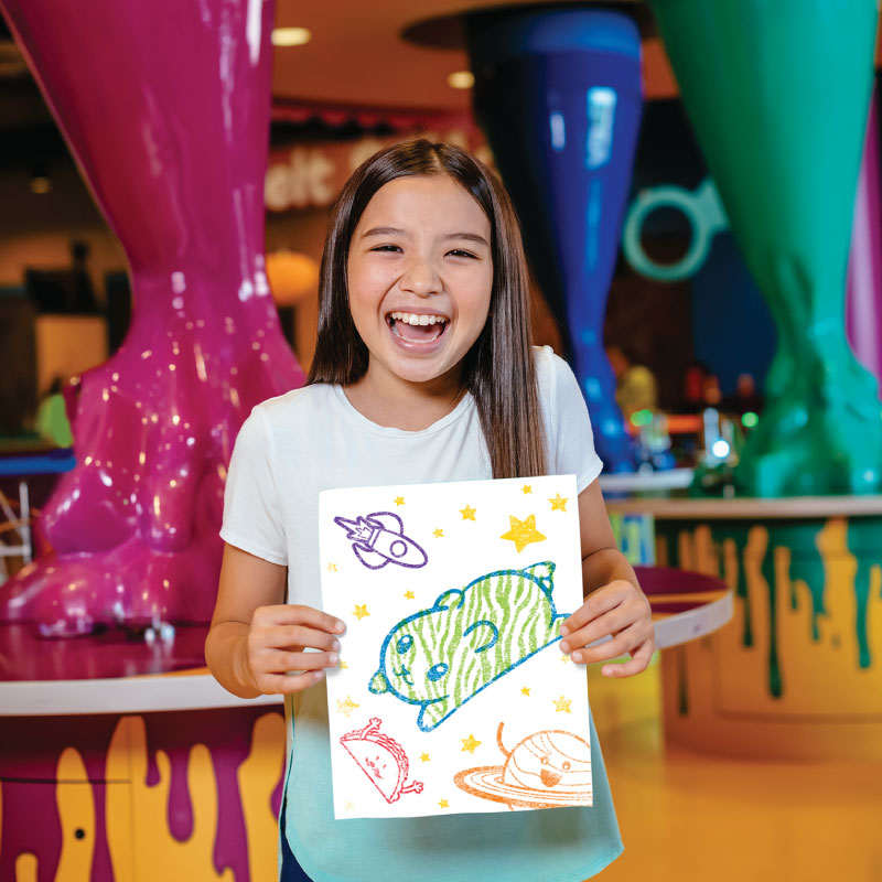 Child holding out crayon rubbing art