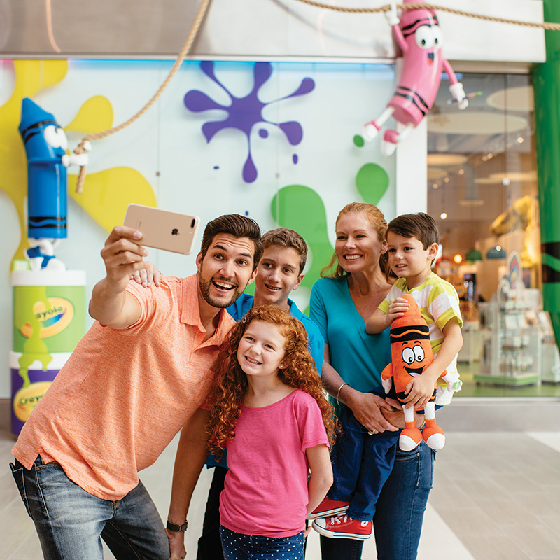 Family posing for a photo in front of Crayola Experience