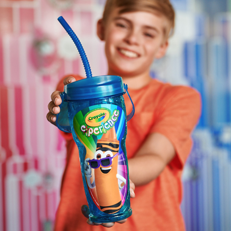 Kid holding out a souvenir drink cup