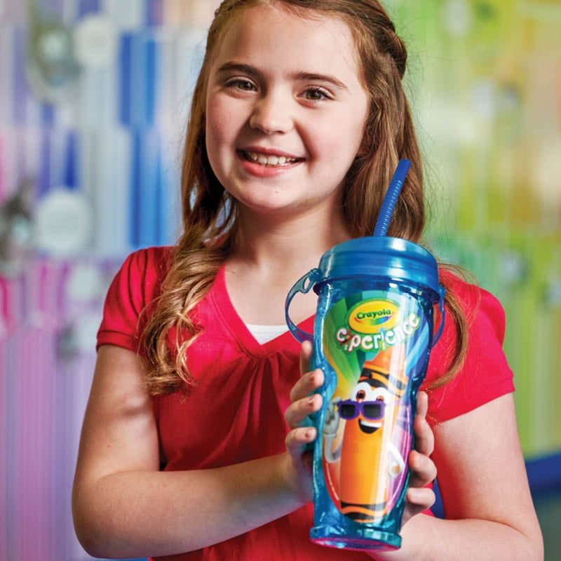 Child holding out souvenir drink cup