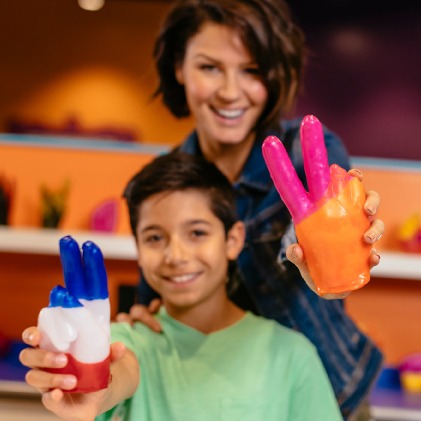 Mom and child holding out colorful wax hands