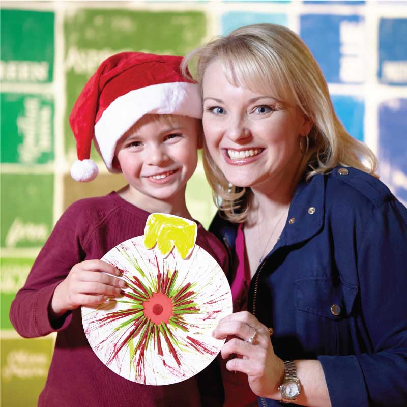 Adult and child holding up a holiday craft