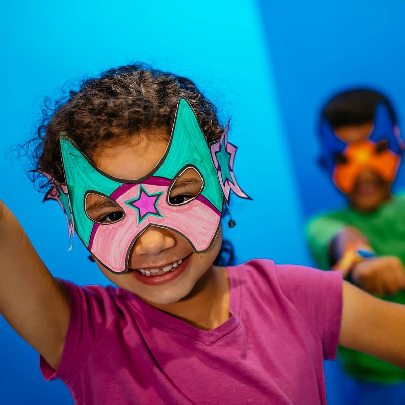 Child wearing a crafted superhero mask