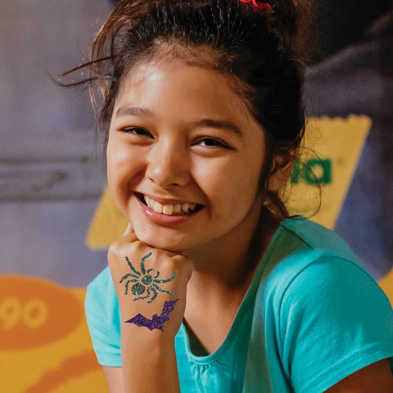 Child with glitter tattoos with Halloween designs