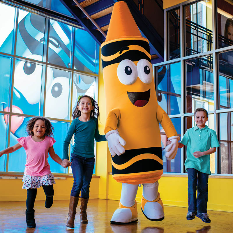 Children standing with Sunny the crayon