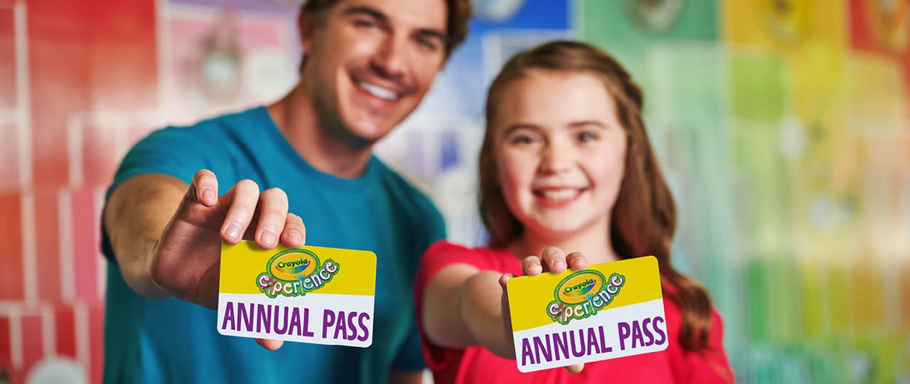 Two people holding out Annual Passes